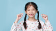 © DN6 - Asian child's hand shows the fallen out small white milk teeth close-up, Dentistry and Health care concept, Empty space isolated on blue background