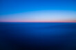 © Monet_P - Minimal aerial seascape at dawn with soft pink and blue gradient over calm ocean horizon, showing peaceful twilight colors and infinite natural tranquility