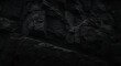 © Odye Design Art - Close-up of a dark, textured rock face with shadows and varying shades of gray, creating a rugged and natural pattern.