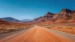© backup_studio - Long empty road through a vast red desert landscape with mountains under a clear blue sky. Travel adventure journey concept.