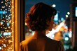 © starush - A woman looks out a window at night with city lights and bokeh in the background