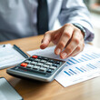 © Danielle - Close up businessman hand using calculator to budgeting and tax calculation monthly expenses. budget management and accounting on table. Business finance accounting banking concept.