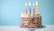 © wolfelarry - Colorful birthday cake with lit candles on a light blue background.