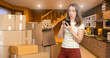 © Grispb - Woman checking phone during home move with cardboard boxes and teddy bear in cozy wooden kitchen. Activity: Moving, Relocation, Real estate, Home organization, Delivery.