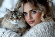 © Yuliia - Young blonde woman with blue eyes and natural makeup embracing fluffy maine coon cat in cozy white knit sweater, close up portrait with soft bokeh background.