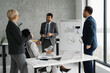 © Novak - Group of four business professionals discussing ideas in a modern office