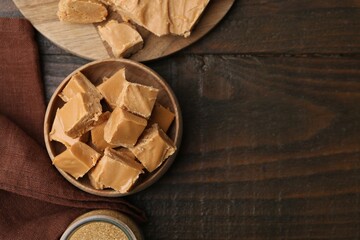Wall Mural - homemade caramel candies and brown sugar on wooden table, flat lay. space for text
