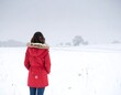 © wedang - Woman in red coat on snowy field