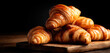 © Alexander - Stack of golden flaky croissants on wooden board. Delicious french pastry, perfect for breakfast or snack. Freshly baked viennoiserie for bakeries and food concept.