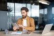 © Liubomir - Professional man using tablet device at office desk with laptop