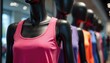 © Maryna - Black mannequins display colorful athletic tank tops in modern retail store environment. Variety of vibrant activewear apparel including pink, purple, orange, blue options for active lifestyles.