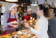 © JackF - Girl bakery assistant consults customer, tells about availability of gluten-free, lactose-free and meat-free baked goods. Products for people with food intolerances and allergies