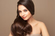 © Oleg Gekman - Brunette girl with perfect makeup. Smiling beautiful model woman with long curly hairstyle. Care and beauty hair products