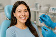 © Celt Studio - Smiling female dental patient sitting relaxed dentist chair confident white teeth preventive oral care promotion modern clinic interior
