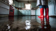 © Daniel - Flooded kitchen floor; person in red boots surveying the damage. Water damage and home emergency.