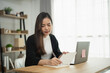 © WMSTUDIO - Young woman writing notes in a notebook while sitting at a desk with a laptop, minimalistic workspace, natural light, focus on productivity and organization