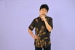 © Freddy Chandra - man in batik traditional shirt posing thoughtfully against purple background