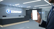 © Aiustock - Businessman Holding Smartphone with Blank Screen in Modern Office Lobby