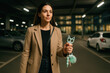 © sakson - Empowered woman with self defense keychain in urban parking garage at night focused on safety and confidence