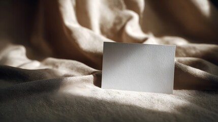 Wall Mural - blank greeting card on a soft fabric surface with warm lighting