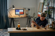 © pressmaster - Young Caucasian man spending morning at home opening bottle with milk and watching something on smartphone