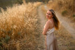 © Mariia Andreeva - Slavic woman with long white hair standing in golden grass field, natural beauty and ethnic portrait in summer countryside landscape at sunset.