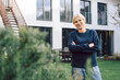 © TrueShot | Westend61 - Woman gardener smiling with crossed arms in a garden