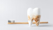 © hardvicore - Tooth model with dirty stains and wooden toothbrush on light background. Dental care, hygiene