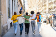 © TrueShot | Westend61 - Rear view of group of friends walking arm in arm in the city