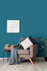 Poster - interior of living room with armchair and books on table