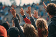 © Vitalii Shkurko - A group of excited fans with hands raised in anticipation at an outdoor sporting event. The atmosphere is lively as attendees show their support for the teams