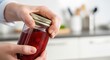 © Aurora Aesthetics - Person hands struggling to open a tight glass jar of jam in the kitchen domestic life and problem solving concept