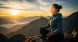 © RONNY - Woman meditating atop mountain peak at sunrise.  Vast landscape of misty mountains stretches out