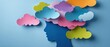 © Fernando - Colorful paper clouds above blue silhouette of womans head Concept of mental health, creativity, and imagination