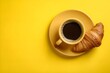 © KAMAPAN - Coffee espresso cup and fresh croissant on a yellow background. Creative layout and concept of healthy food and french breakfast. Top view and copy space.