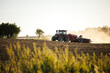 © encierro - Modern agricultural tractor with seeder on dusty field during summer sowing new crops for next season. Farming machinery preparing soil and planting seeds in rural countryside