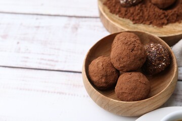 Wall Mural - Delicious homemade candies with cocoa powder on white wooden table, closeup. Space for text