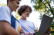 © zinkevych - Teens in the park with laptop and books preparing for the lessons