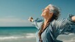 © Johannes - happy mature woman with arms outstretched feeling the breeze at beach beautiful middle aged woman with arms up dancing on beach mid lady feeling good and enjoying freedom at sea copy space no logos n