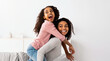 © Prostock-studio - Happy Loving Family. Cheerful African American man and woman having fun with children in living room, giving smiling boy and girl piggyback ride. Four positive black people spending time together