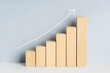 © Abdull - Wooden block financial bar chart graph with upward trend line drawn on background. Growing business concept