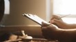 © VAKSMANV - Close-up of male hands holding clipboard. Flipping paper sheets and holding pencil. Checking roasting records and updating information while standing near coffee bean processing machine.