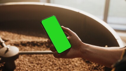 Mockup, man hand holding using mobile phone at coffee shop with copy space, blank screen for text, mobile app design and advertising, online marketing.
