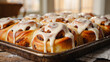 © WIKKI.White - Freshly baked cinnabon rolls with cream cheese icing on tray