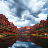 A breathtaking view of a majestic canyon with towering red rock cliffs, mirrored flawlessly in a serene, reflective river beneath dramatic stormy skies, invoking awe and tranquility.