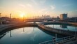 © Vadym - Water treatment plant at sunrise with city skyline in background. Large tanks, circular basins reflect calm water under warm morning sun. Industrial facility modern infrastructure for water