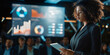 © Gabriela - An African American businesswoman, holding a tablet in front of an audience and a screen full of graphics