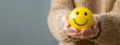 © Daniel - Woman hand holding happy smile sphere, Positive thinking, Mental health assessment , World mental health day concept
