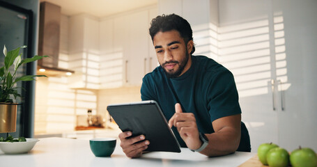 Tablet, coffee and man in kitchen in morning with networking, communication or app. Digital technology, research and male person with cappuccino for texting, contact or social media in apartment.