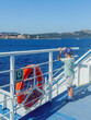 © Elena - Child Enjoying Scenic Ferry Ride with Life Buoy
